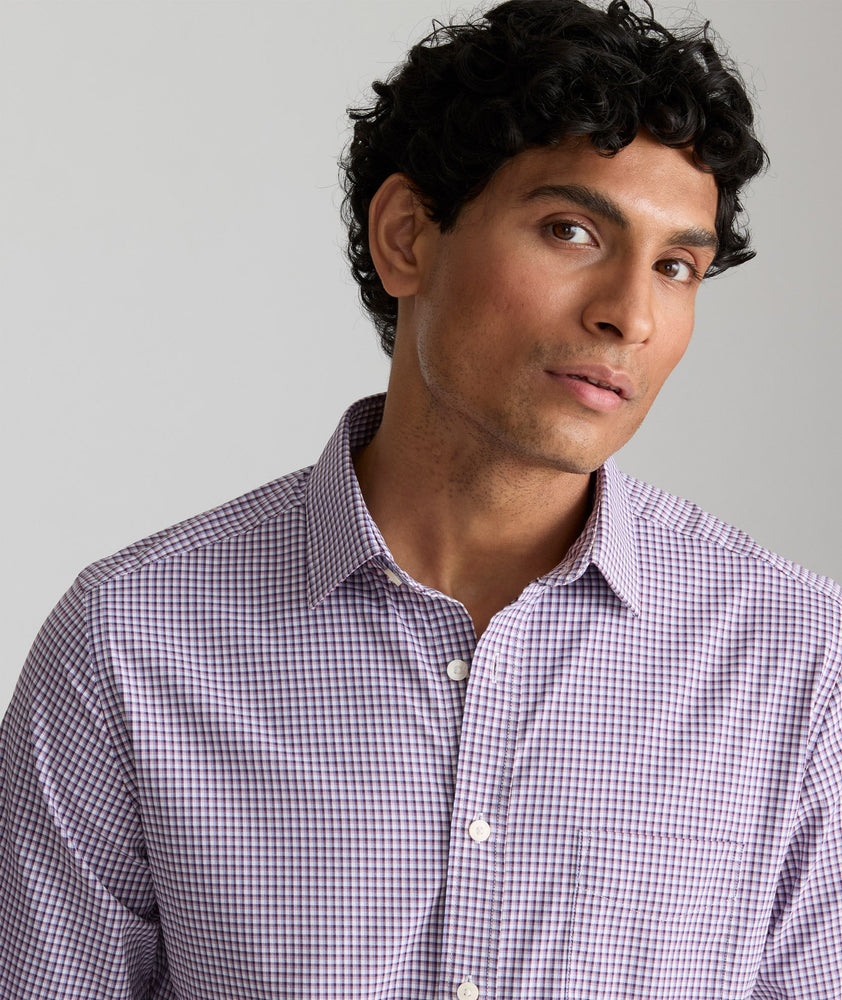 Model is wearing UNTUCKit Alvarado shirt in small plum and maroon check. 