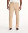 Model is wearing UNTUCKit Traveler Tech Pants in Tan. 