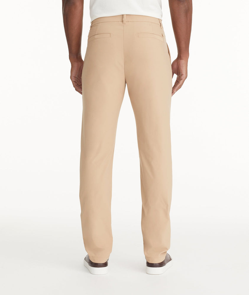 Model is wearing UNTUCKit Traveler Tech Pants in Tan.