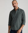 Model is wearing UNTUCKit Harris shirt in green and navy small check. 