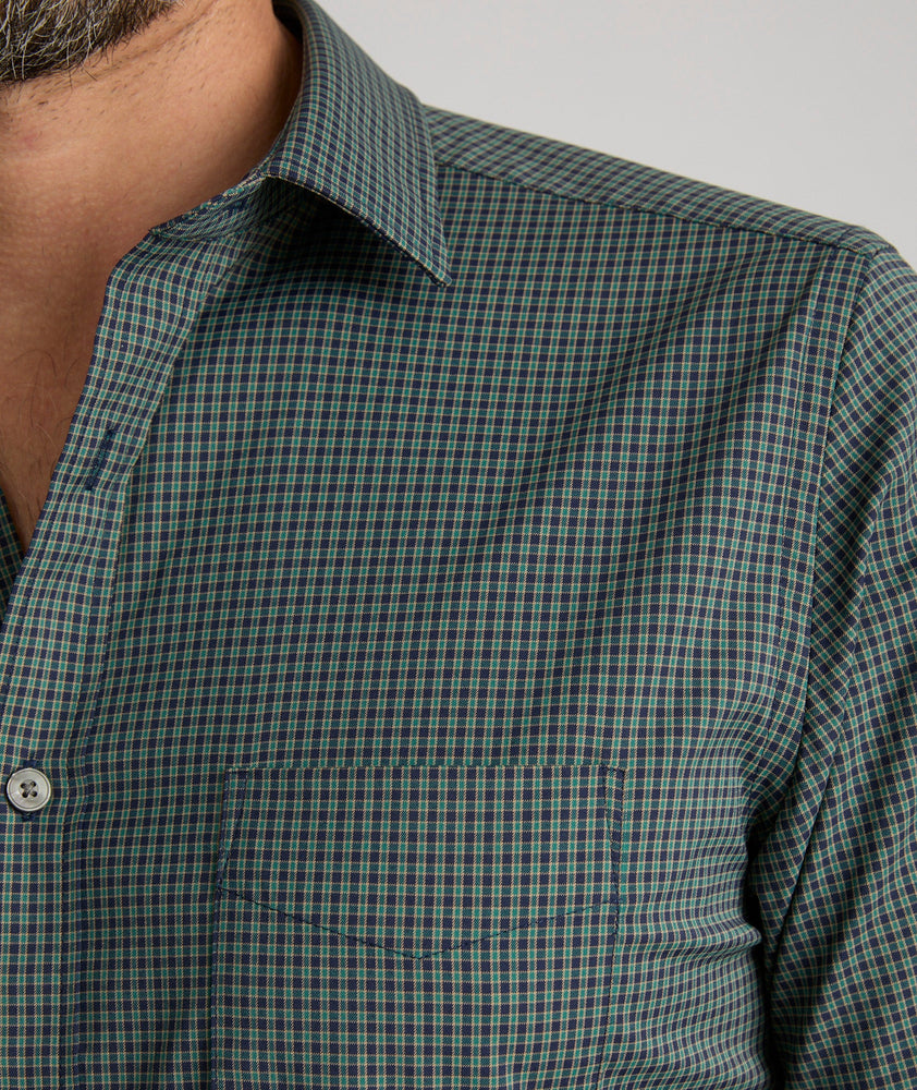 Model is wearing UNTUCKit Harris shirt in green and navy small check. 