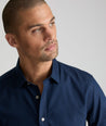 Model is  wearing UNTUCKit Johnston wrinkle-free shirt in navy and blue gingham.