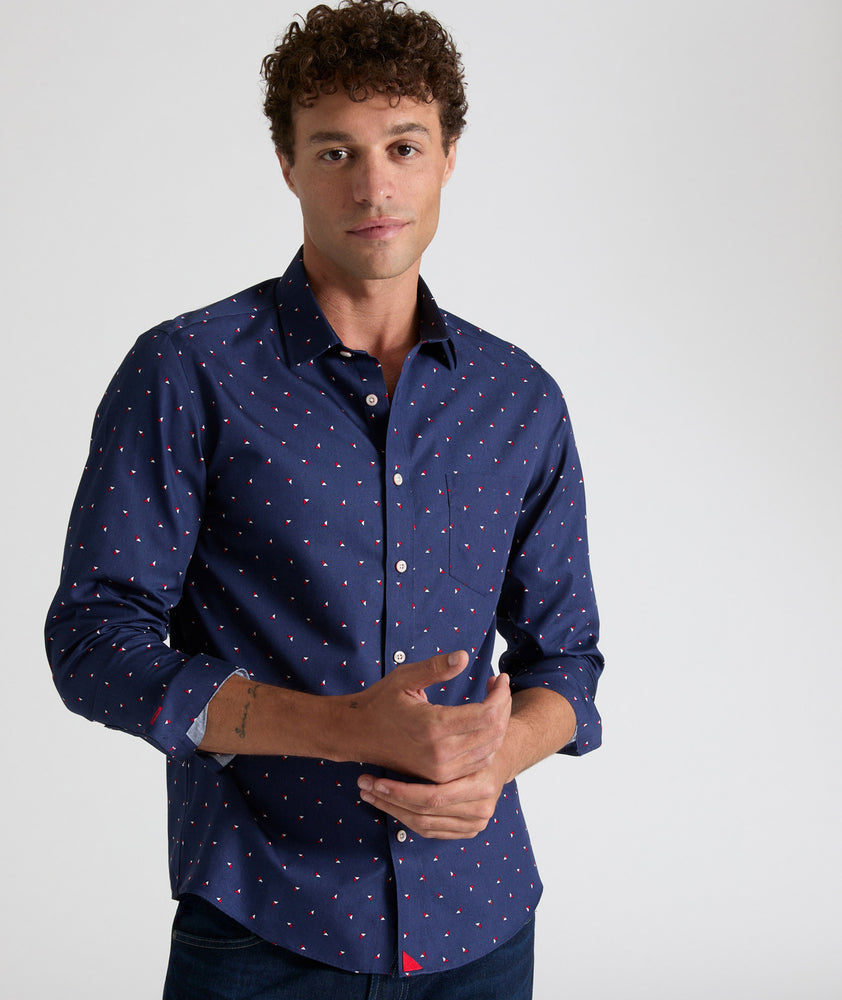 Model is wearing UNTUCKit Kipling shirt in navy with white and red triangles. 