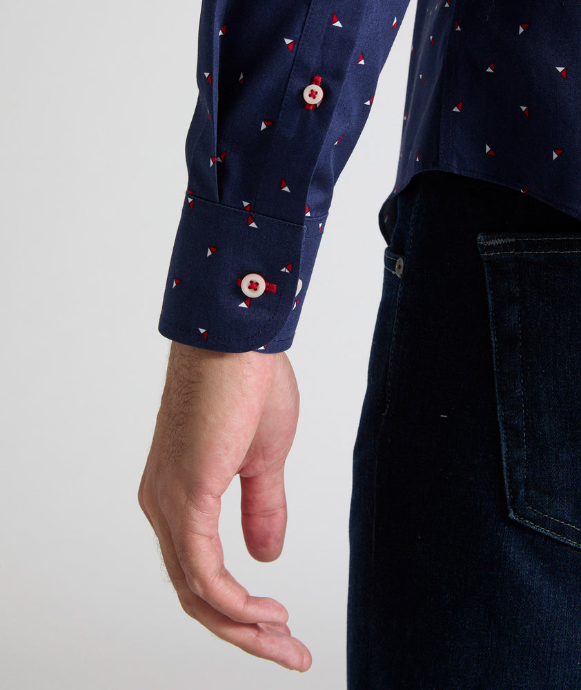 Model is wearing UNTUCKit Kipling shirt in navy with white and red triangles. 