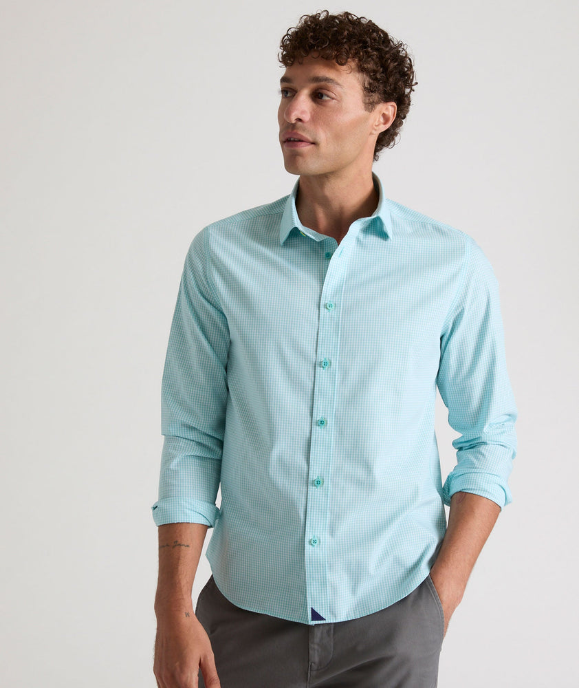 Model is wearing UNTUCKit Travelers shirt in teal tiny gingham. 