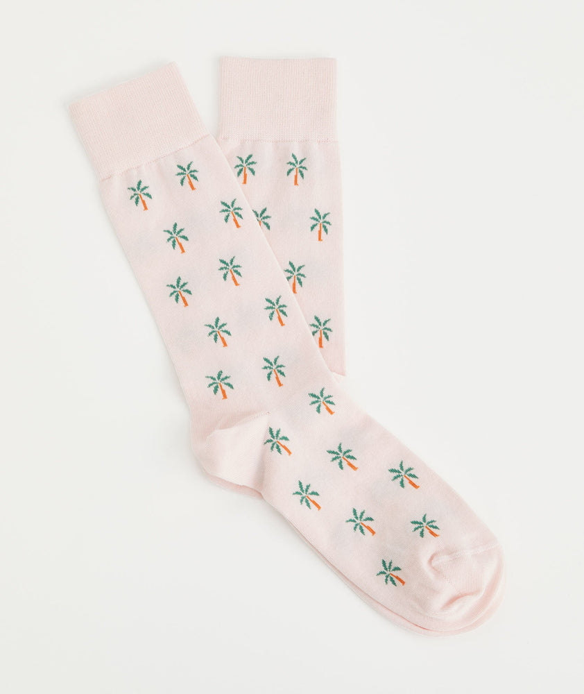 Model is wearing UNTUCKit Pink Dogwood Palm Tree classic cotton socks.