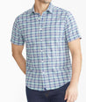 Model is wearing UNTUCKit Navy & Teal Check Wrinkle-Free Performance Short-Sleeve Henderson Shirt.